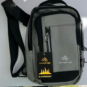 NWT Mountain High sling bag by Everbright. Multiple zipper pockets.